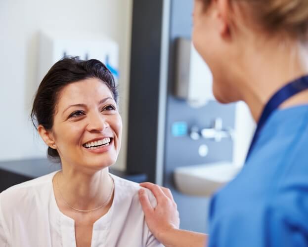 Woman talking to dentist about whole body dentistry approach