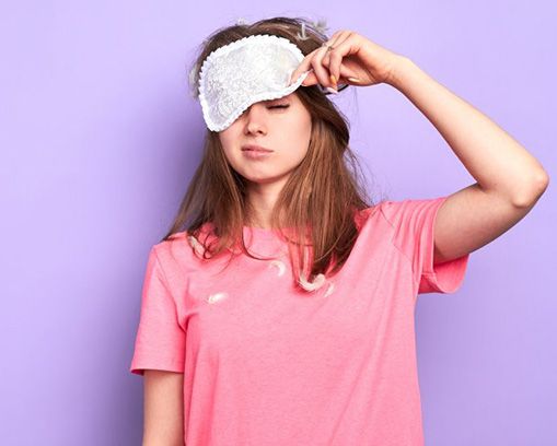 Woman lifting a sleep mask from her face 