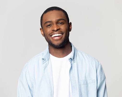 man in light blue shirt grinning