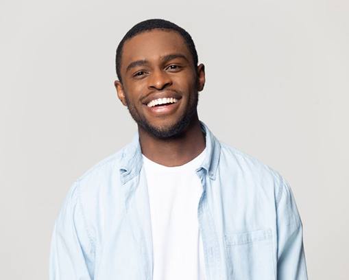 man in light blue shirt grinning 