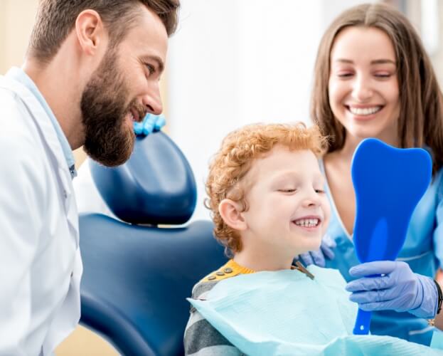 Child smiling after receiving kid friendly dental services