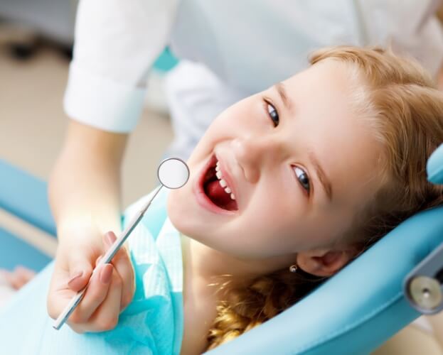 Young child smiling while receiving healthy start treatment