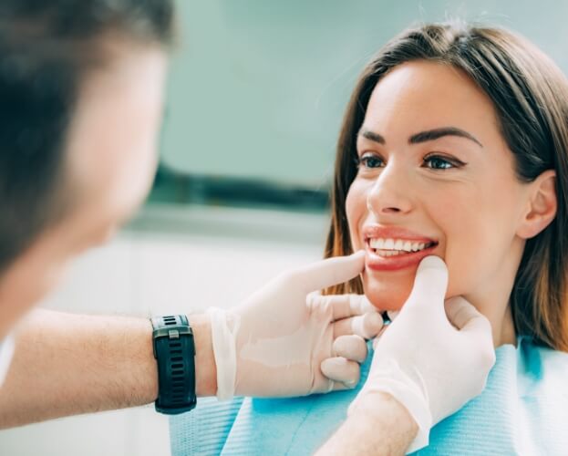 Dentist examining smile after porcelain veneers