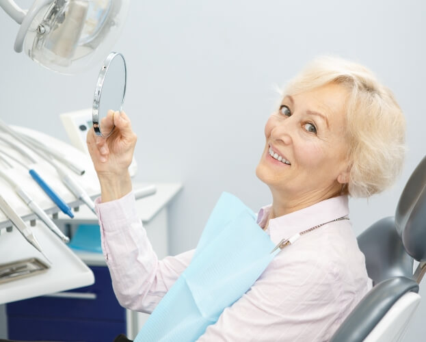 Woman smiling after receiving answers to frequently asked dentures questions