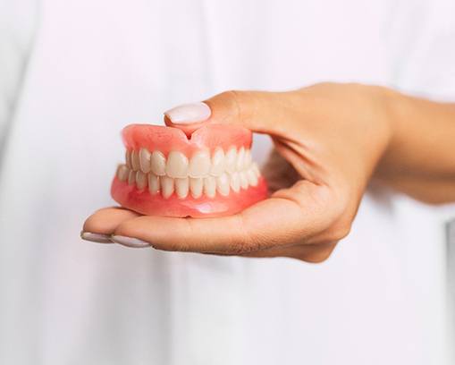 Dentist holding full dentures