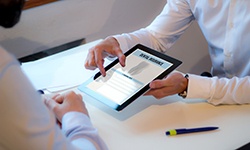 Dentist holding a tablet showing a dental insurance form