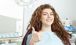 Female dental patient giving a thumbs up