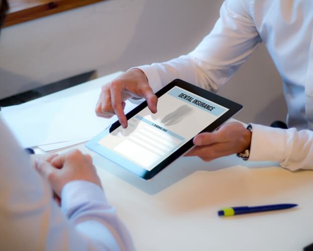 Dental patient looking at dental insurance forms on tablet computer