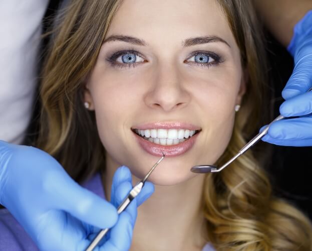 Woman smiling during teeth whitening treatment