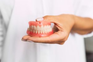 doctor holding dentures in Casper