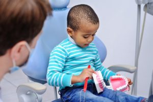 a child learning about how to brush their teeth from their children's dentist in Casper