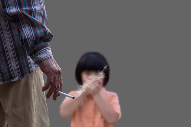 man smoking in front of a child