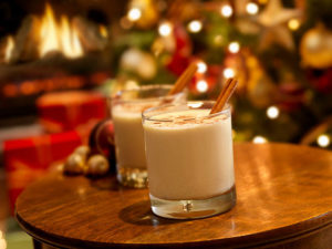 Two small glasses of eggnog on wooden table