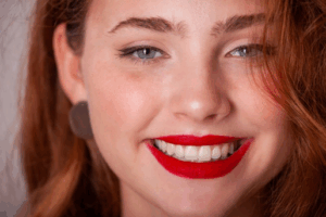 Woman with perfect teeth and red lipstick smiling