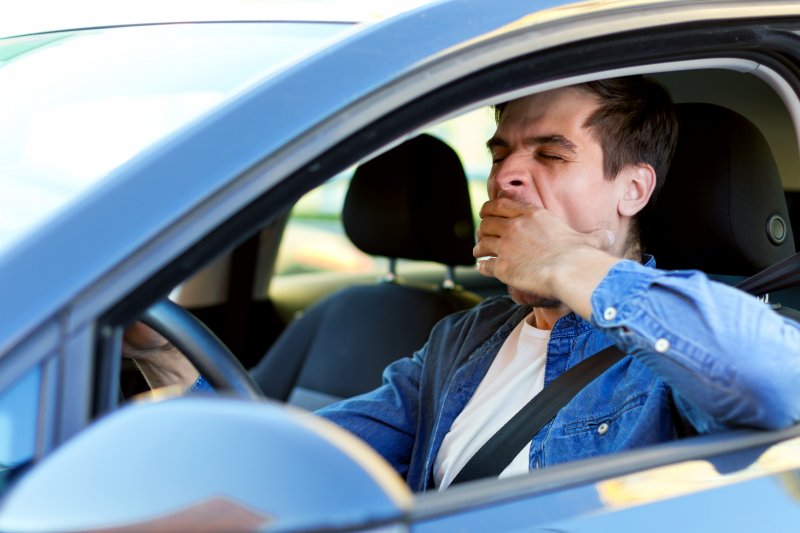 Man yawns while driving