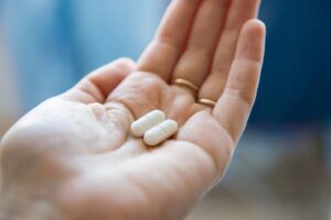 Hand holding two pills.